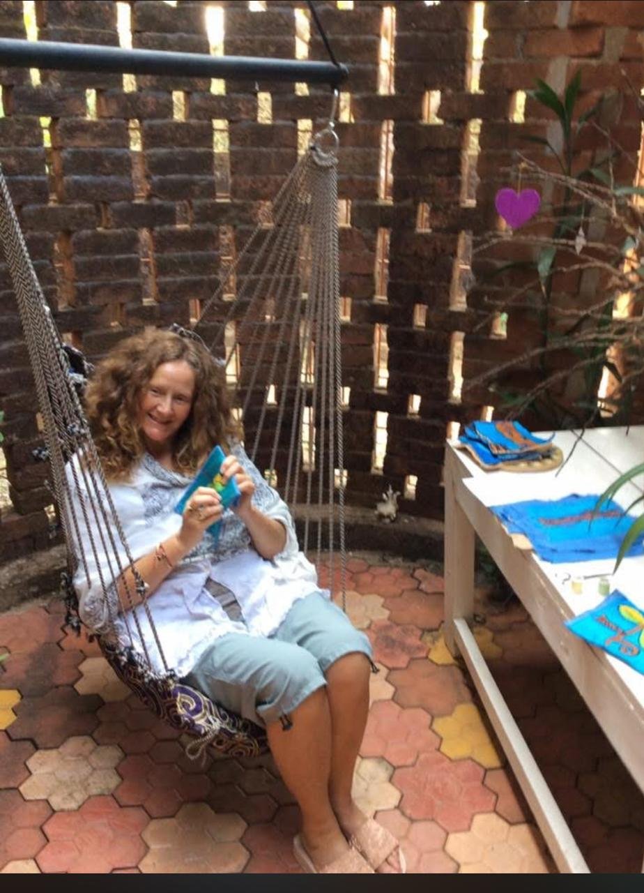 Janet Sylph embroidering in a hammock at Peace Cottage